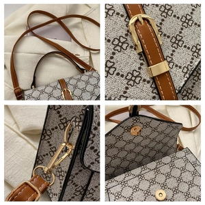 Macro detail of clover pattern canvas and polished gold hardware on retro crossbody bag
