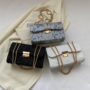 Three minimalist textured oxford cloth crossbody bags with gold chain straps in various colors