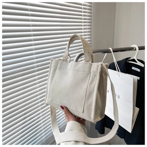 Détail du sac cabas en velours côtelé crème avec poche frontale et bandoulière large