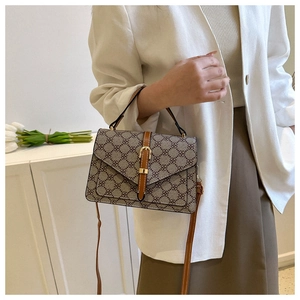 Detail of vintage crossbody bag with floral monogram print and gold metal buckle