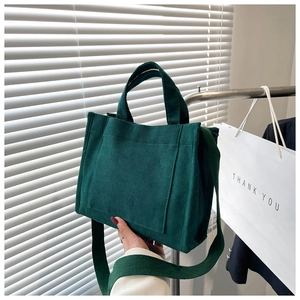 Détail du sac cabas en velours côtelé vert foncé montrant la texture et la bandoulière