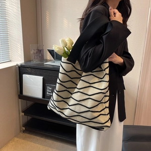 Minimalist knit tote bag with black wave pattern and wide shoulder strap for women