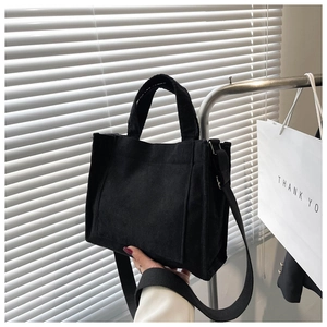 Détail du sac cabas en velours côtelé noir avec texture striée et poche frontale