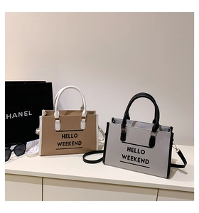 Détail de sacs cabas bicolores minimalistes avec texte HELLO WEEKEND et bandoulières