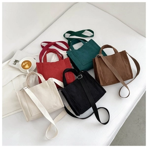 Gros plan de cinq sacs à bandoulière en velours côtelé en beige, rouge, vert et noir