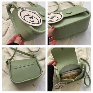 Detailed interior and exterior views of a light green saddle bag with a bear charm