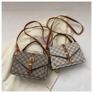Flat lay of vintage monogram flap bags in two colors with gold-tone buckle and crossbody strap