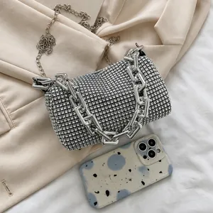 Detailed close-up of a silver rhinestone evening bag with elegant chain straps and texture