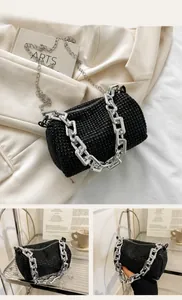 Macro detail of black cylindrical evening bag with rhinestones and chunky silver chain