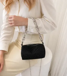 Detail of black rhinestone cylindrical evening bag with silver chain handle and strap