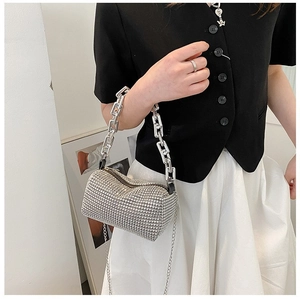 Close-up of cylinder evening bag with silver rhinestones and chunky metal chain handle
