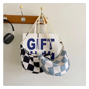 Detail showing checkered canvas hobo bags in blue and black with adjustable straps