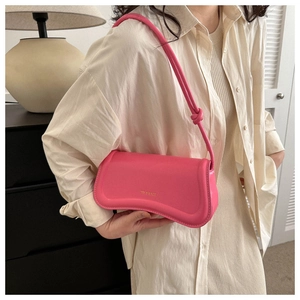 Chic bright pink leather underarm bag with curved base and knot detail on the strap
