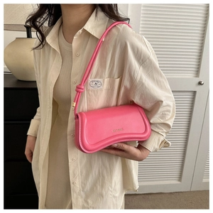 Close-up of pink faux leather underarm bag featuring the XM & BAGS logo and knot strap