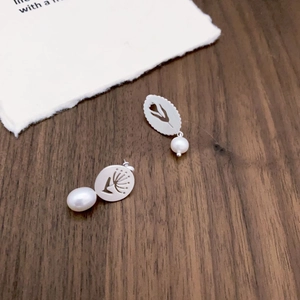 Asymmetric silver oval stud earrings with hollow floral patterns and hanging pearls