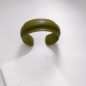Minimalist olive green leather open cuff bracelet with contrast stitching on stone decor