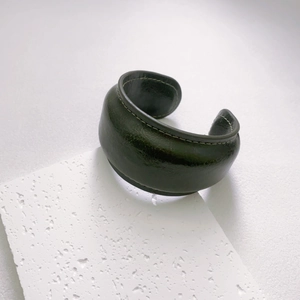 Minimalist wide dark green leather cuff bracelet with white contrast stitching detail