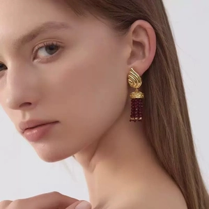 Détail de boucles d'oreilles à pompons vintage avec perles de grenat rouge pour un look rétro