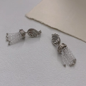 Boucles d'oreilles vintage avec glands perlés et design d'aile à volutes sophistiqué