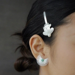 Ethnic silver hair clip with white pearl and green gemstone earring on a model