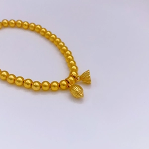 Elegante bracciale con perline dorate e ciondoli a campana e nappa da donna