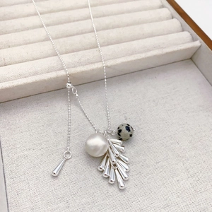 Détail du collier avec perle, pierre dalmate et pampilles en métal argenté design