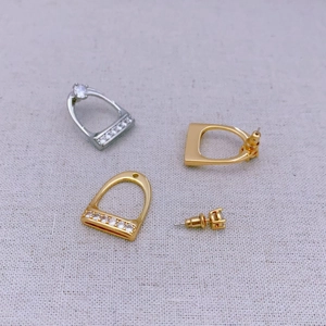 Detail of horseshoe-shaped earrings with inlaid diamonds and gold silver dual finish