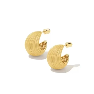 Close-up of 18K gold earrings with radial texture and hollow mesh structure detail