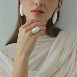 French vintage spiral textured matte white earrings and ring set worn by a model
