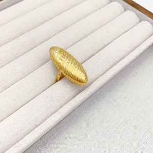 Macro detail of golden spiral spindle ring with brushed texture on velvet display