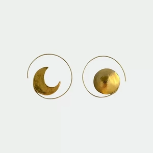 Detail shot of hammered gold sun and moon mismatched hoop earrings with unique textures