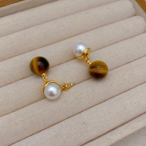 Elegant gold-plated tiger eye and pearl drop earrings displayed in a luxury jewelry box