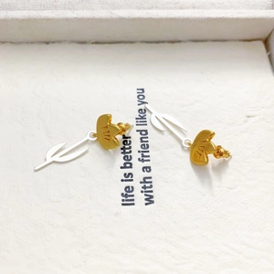 Elegant two-tone gold and silver tulip stud earrings on minimalist ivory art card