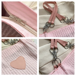 Dettagli della borsa tote rosa trapuntata con toppa a cuore, zip e catenella