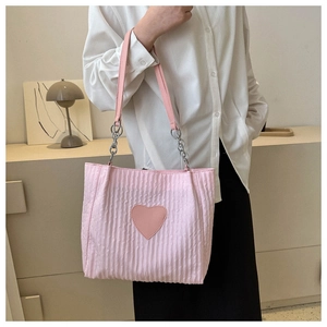 Dettaglio della borsa tote trapuntata rosa con patch a cuore e tracolla a catena