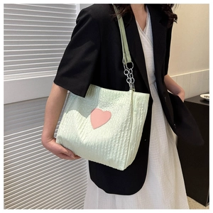 Dettaglio della borsa a spalla plissettata verde menta con cuore rosa e catena argento