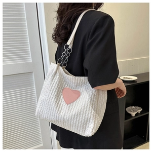 Dettaglio della borsa shopper bianca a volant con cuore rosa e catena argento