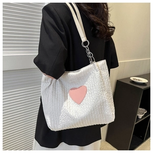 Dettaglio borsa shopper bianca trapuntata con toppa a cuore rosa e tracolla a catena