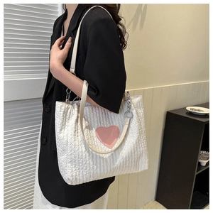 Dettaglio borsa tote in tela bianca con cuore rosa e tracolla a catena argentata