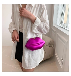 Vue détaillée du sac à bandoulière en forme de lèvres fuchsia avec chaîne dorée