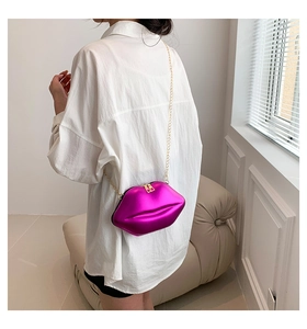 Sac bandoulière en forme de lèvres métallisé magenta avec chaîne dorée sur mannequin