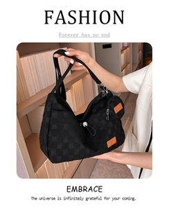 Close-up of black checkerboard tote bag with round coin purse in a library setting