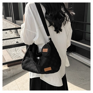 Close-up of black checkerboard canvas tote bag with a matching small round coin purse charm