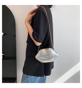 Détail du sac à bandoulière argenté en forme de lèvres avec chaîne dorée brillante