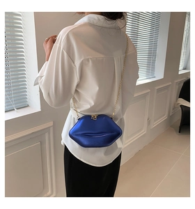 Vue détaillée du sac à bandoulière en forme de lèvres bleu métallisé avec chaîne dorée