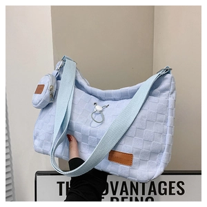 Detail of light blue checkered canvas shoulder bag with small pouch and fashion tag