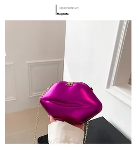 Détail d'une pochette métallisée violet rose en forme de lèvres avec chaîne dorée