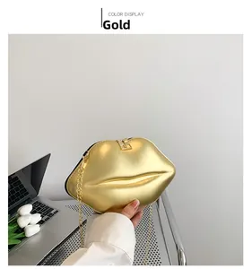 Détail du sac à main doré en forme de lèvres avec finition brillante et chaîne dorée