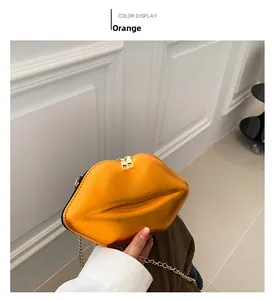 Détail du sac à lèvres orange vif avec fermetures éclair dorées et bandoulière chaîne