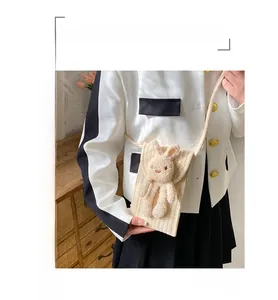 Détail d'un sac de téléphone en coton tissé beige orné d'un adorable lapin en peluche 3D